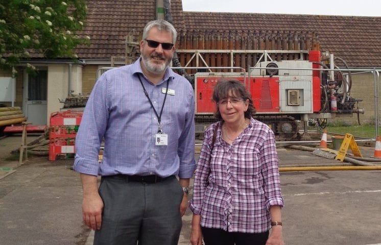 Russ Fowler Director of Financial Reporting & resident Mrs Wilson in front of drilling rig