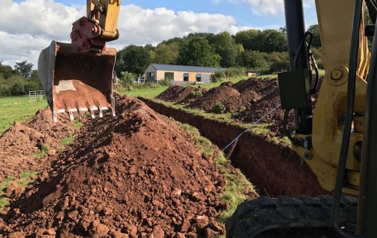 Clifford Place ground source heat pump case study: digger with trenches in view